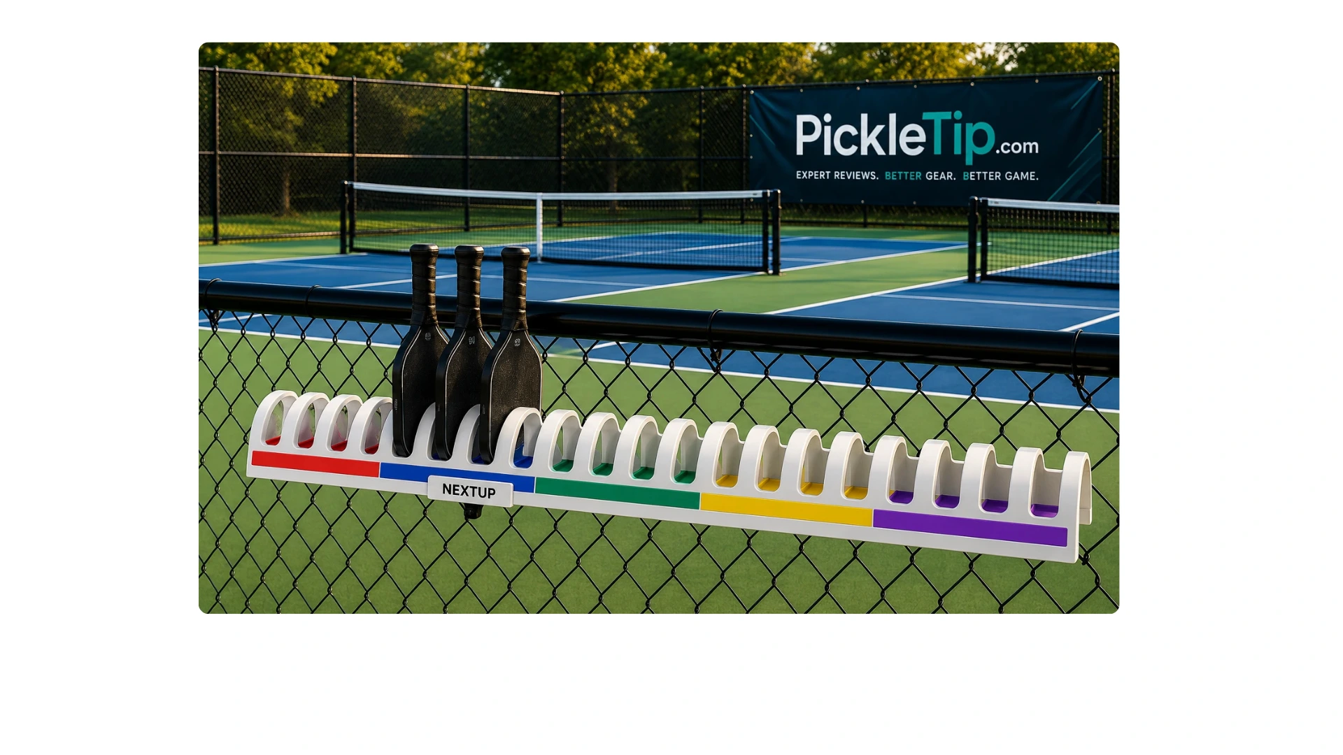 Color-coded pickleball paddle stacking rack on a court fence showing how open play rotation works.
