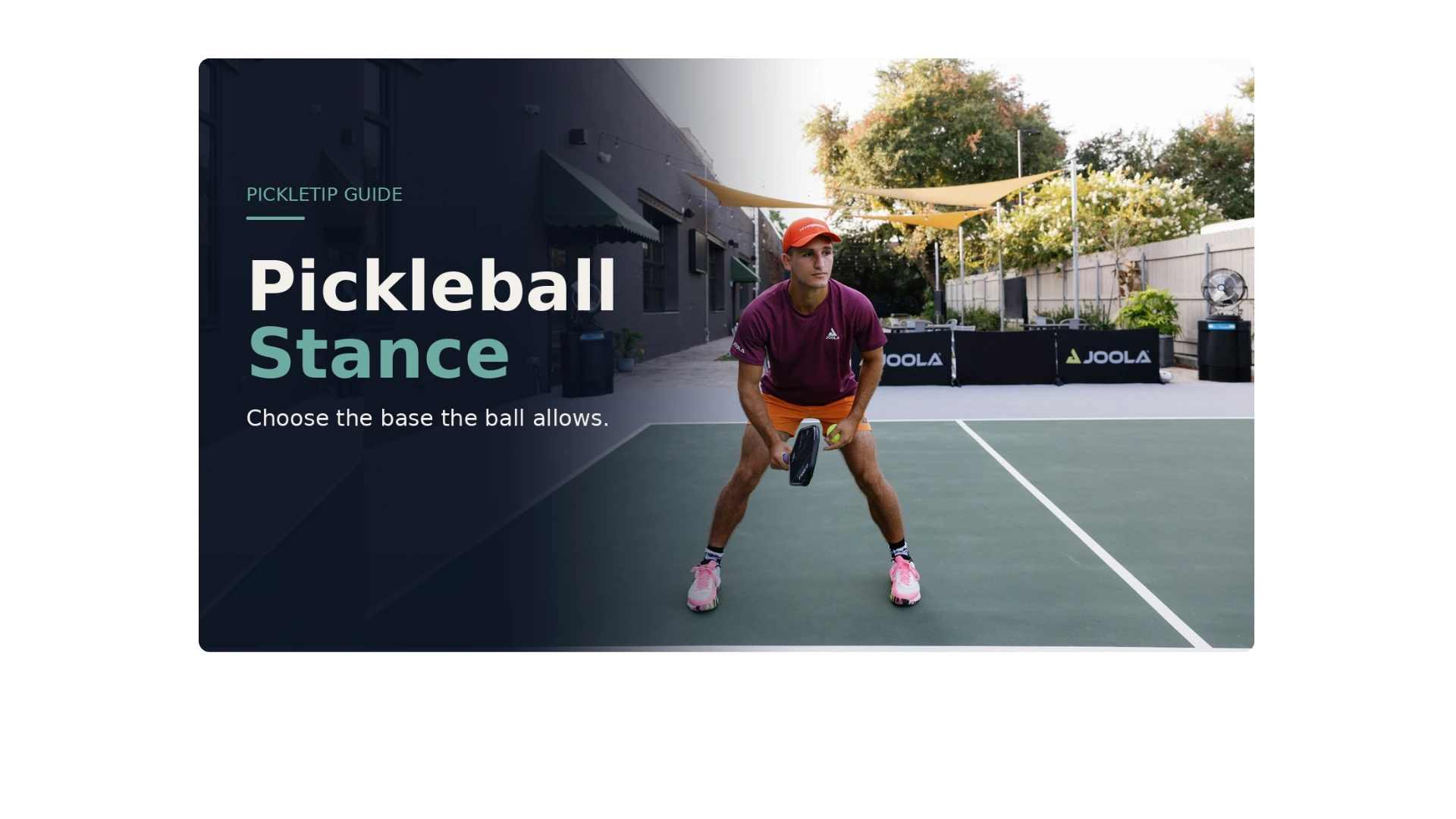 Coach AJ demonstrating a balanced pickleball ready stance with knees flexed, feet apart, and paddle prepared.