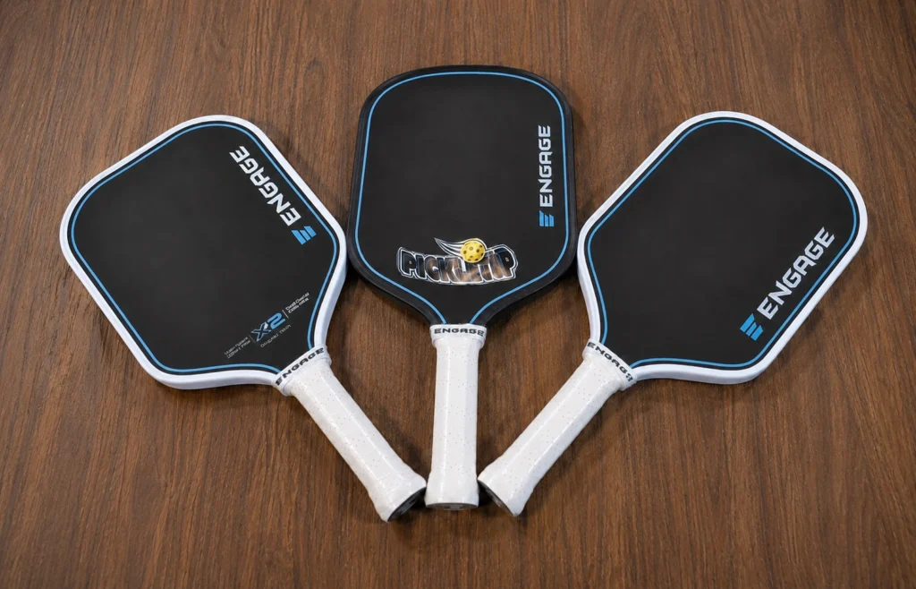 Three Engage X2 pickleball paddles owned and tested for the PickleTip review, including elongated and widebody shapes.