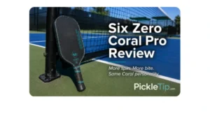 Six Zero Coral Pro pickleball paddle leaning against a net post on an outdoor pickleball court during PickleTip testing